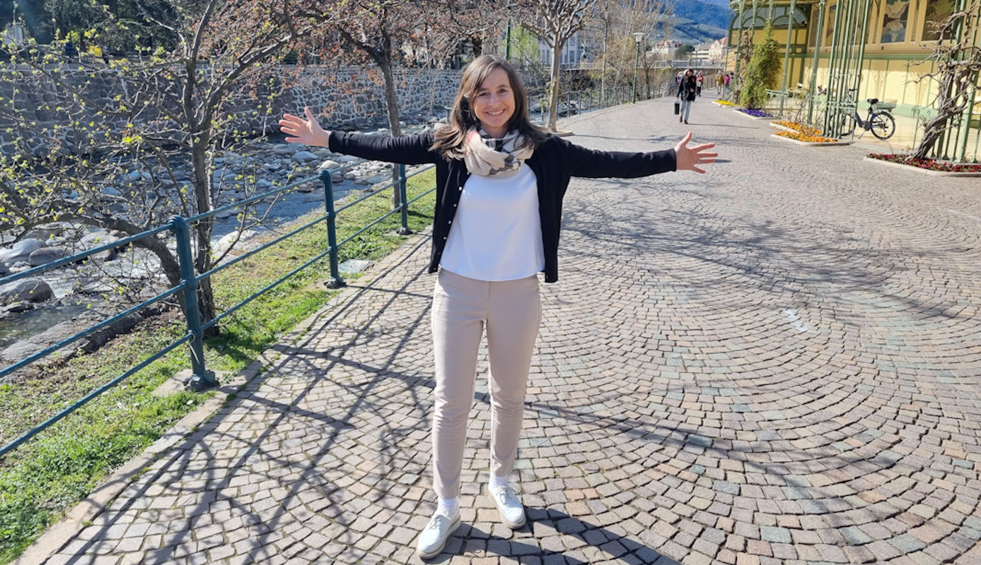 Katharina Kassube mit ausgebreiteten Armen vor einer landschaftlichen Kulisse